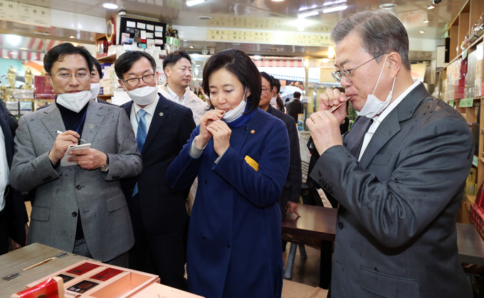 문재인 전 대통령이 2020년 2월 12일 신종 코로나 바이러스 감염증(COVID-19)으로 위축된 내수경제 활성화를 위해 12일 서울 남대문시장을 방문해 홍삼액기스를 구매한 후 시음하고 있다. 오른쪽 두번째는 박영선 당시 중기부 장관/사진=뉴시스.