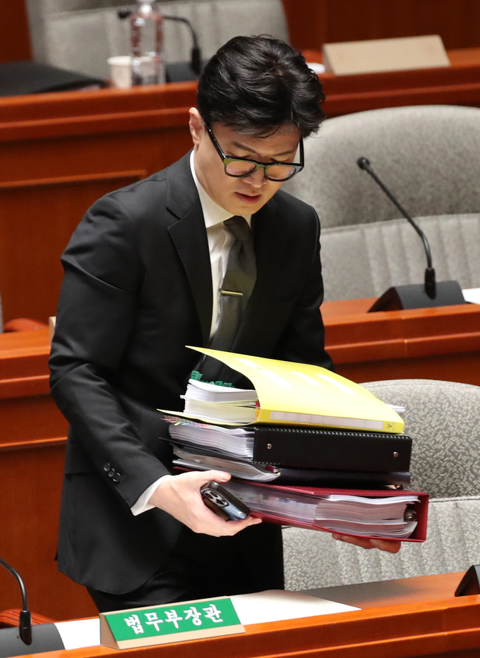 한동훈 법무부 장관이 7일 오전 서울 여의도 국회에서 열린 예산결산특별위원회 전체회의에 자료를 들고 자리에 앉고 있다/사진=뉴시스