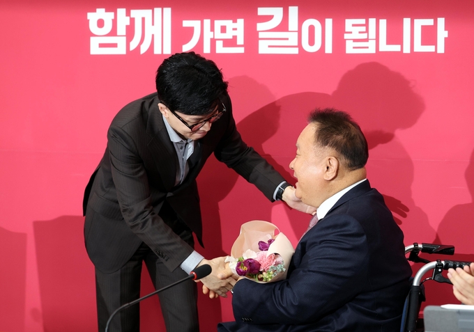 한동훈 국민의힘 비상대책위원장이 8일 오전 서울 여의도 국회에서 열린 비대위 회의에서 이상민 무소속 의원에게 국민의힘 입당을 축하하며 꽃다발을 전달하고 있다/사진=뉴시스