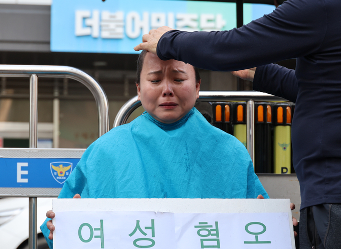 이화여대 졸업생 및 청년박정희연구회 2기 회장인 김다혜 씨가 9일 서울 영등포구 더불어민주당 중앙당사 앞에서 김준혁 경기 수원정 후보의 사퇴를 촉구하며 삭발식을 하고 있다.