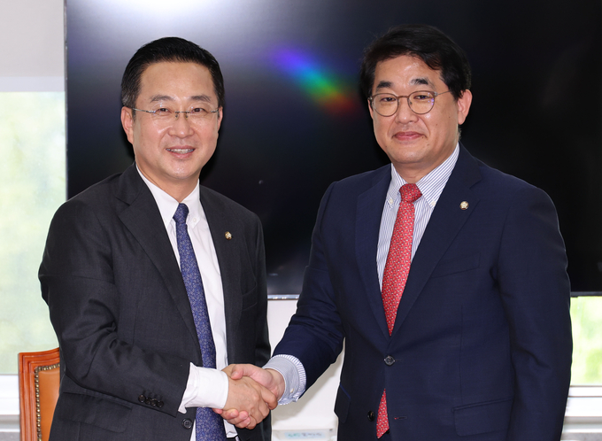 박성준(왼쪽) 더불어민주당 원내수석부대표와 배준영 국민의힘 원내수석부대표가 13일 오후 서울 여의도 국회에서 여야 원내수석부대표 비공개 회동에 앞서 손을 맞잡고 있다. 사진=뉴시스