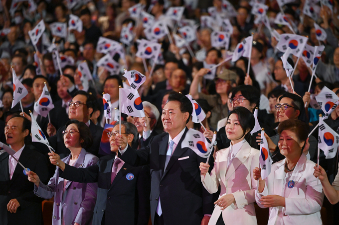 윤석열 대통령과 부인 김건희 여사가 15일 서울 종로구 세종문화회관에서 열린 제79주년 광복절 경축식에서 광복절의 노래에 맞춰 태극기를 흔들고 있다. =대통령실 제공) 사진=뉴시스