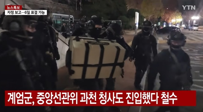 YTN 방송 화면. 중앙선관위 과천 청사에 진입했던 계엄군이 커다란 박스를 들고 있다. 사진=유튜브 캡처