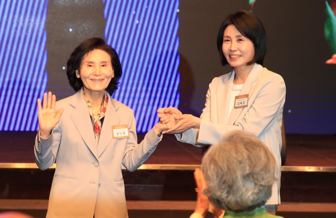 이재명 더불어민주당 대선 후보의 부인 김혜경 여사와 김문수 국민의힘 대선후보의 부인 설난영(왼쪽) 여사가 12일 서울 중구 신라호텔에서 열린 중앙신도회 창립 70주년 기념식에서 손을 맞잡고 있다. 사진=뉴시스